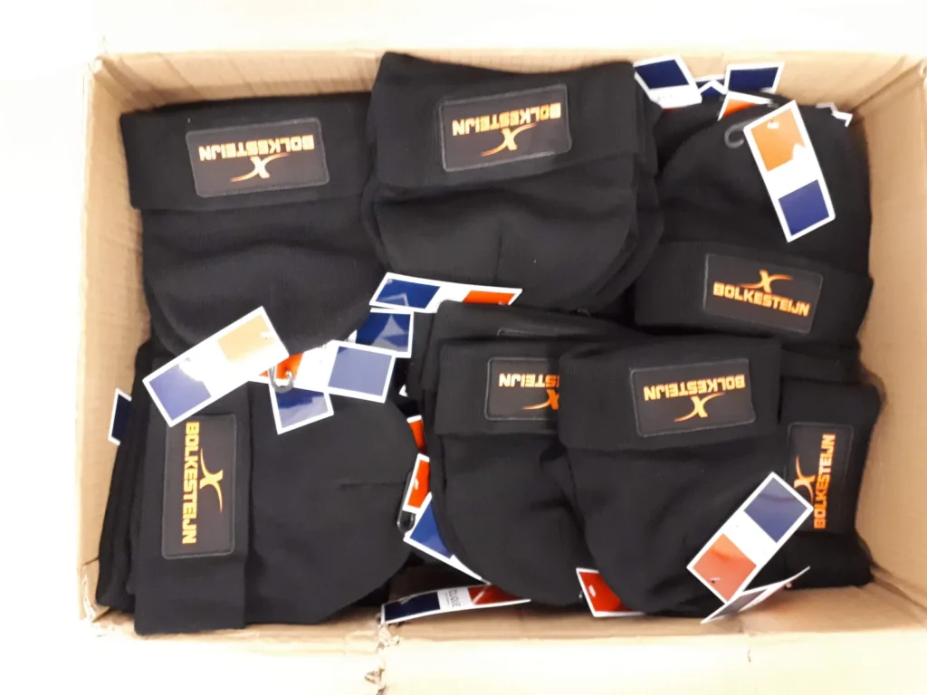 Doos met bedrukte softshell jassen en werkkleding met bedrijfslogo